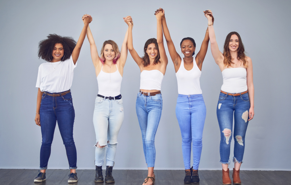 diverse ladies holding hands up in the air