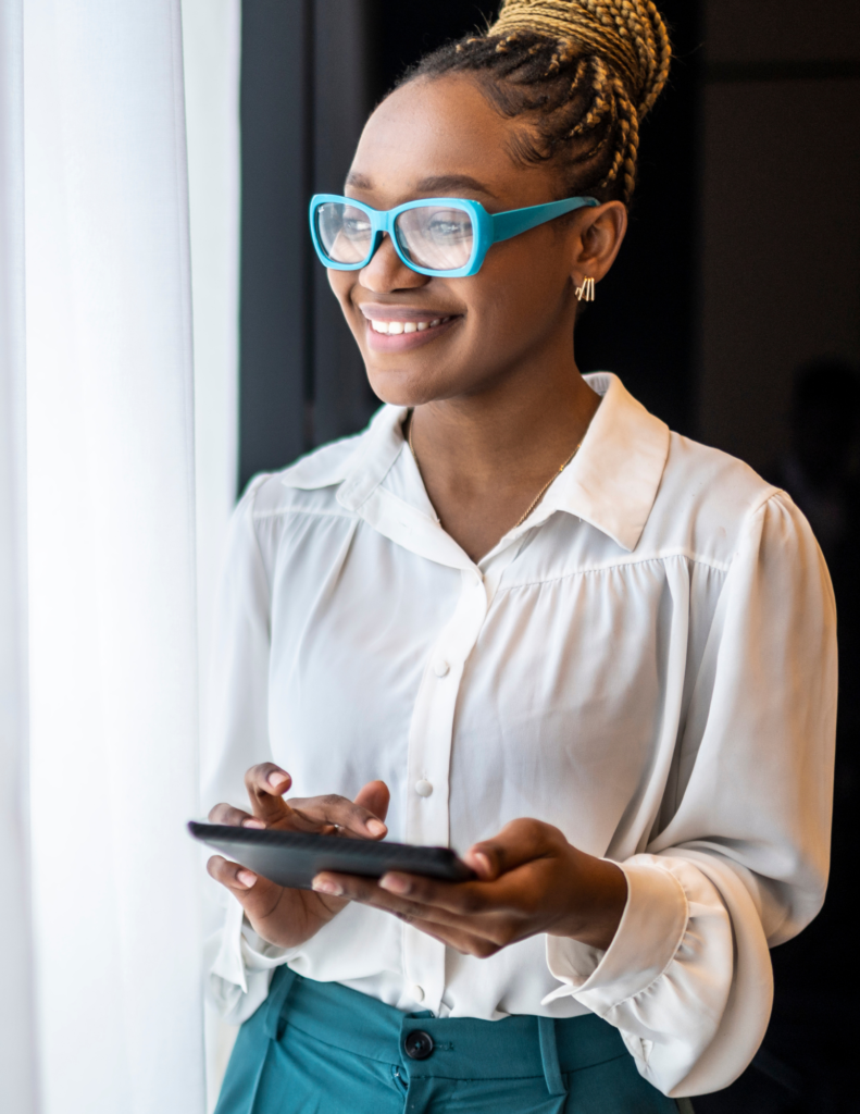 Black Woman with glasses holding phone and smiling