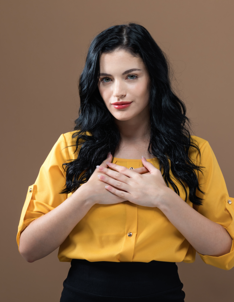 Woman in yellow shirt with hands of heart