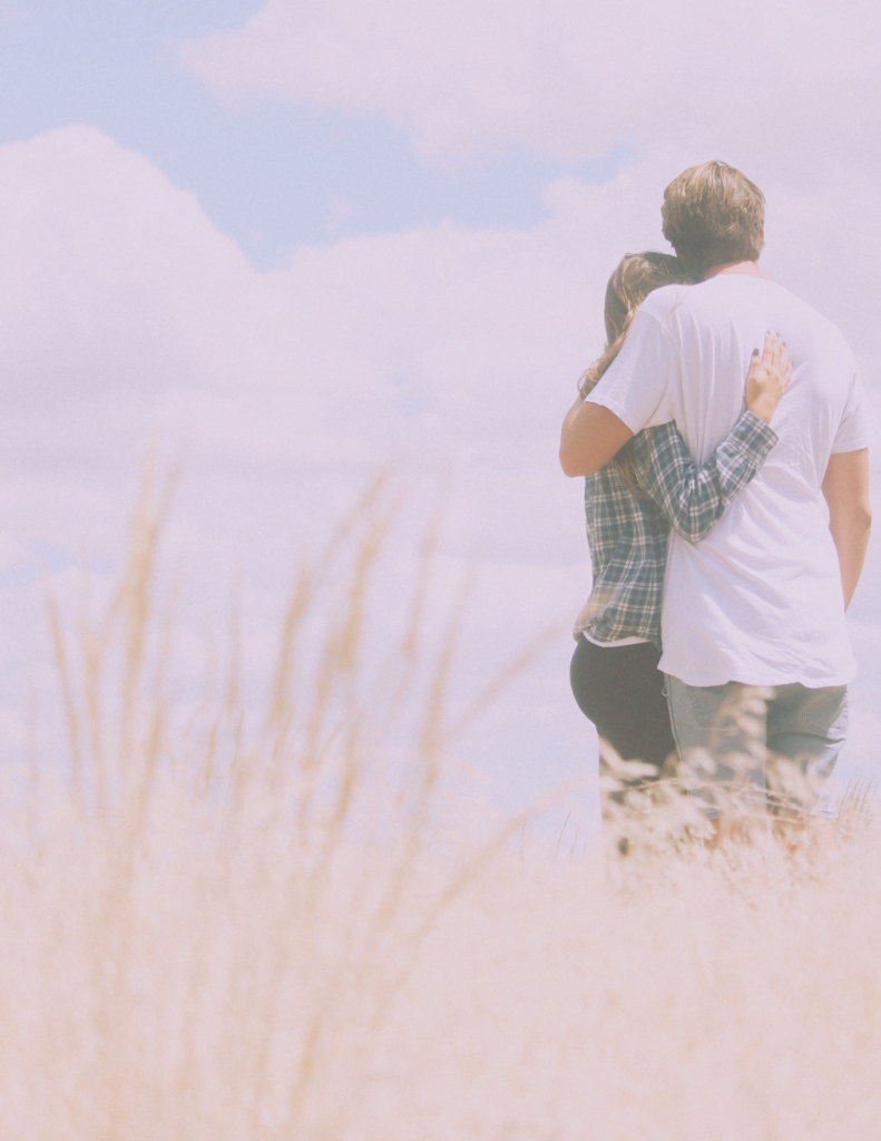 Couple hugging each other in field