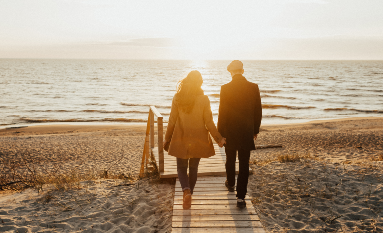 couple walking to ocean holding hands