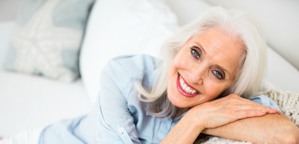 Older lady laying on hands on bed