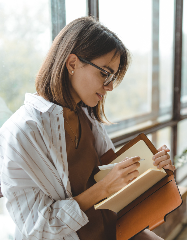 woman holding journal reflecting