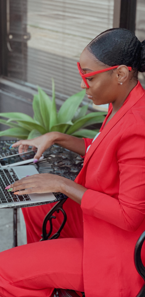 African American woman in red working on computer