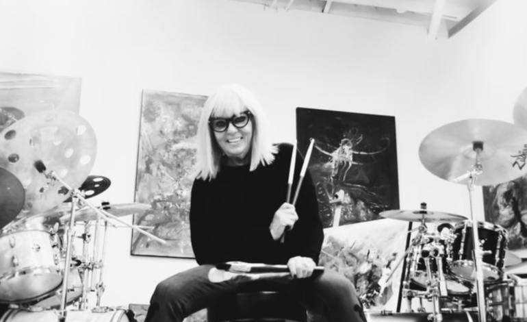 Patricia Gagic holding drum sticks in music studio