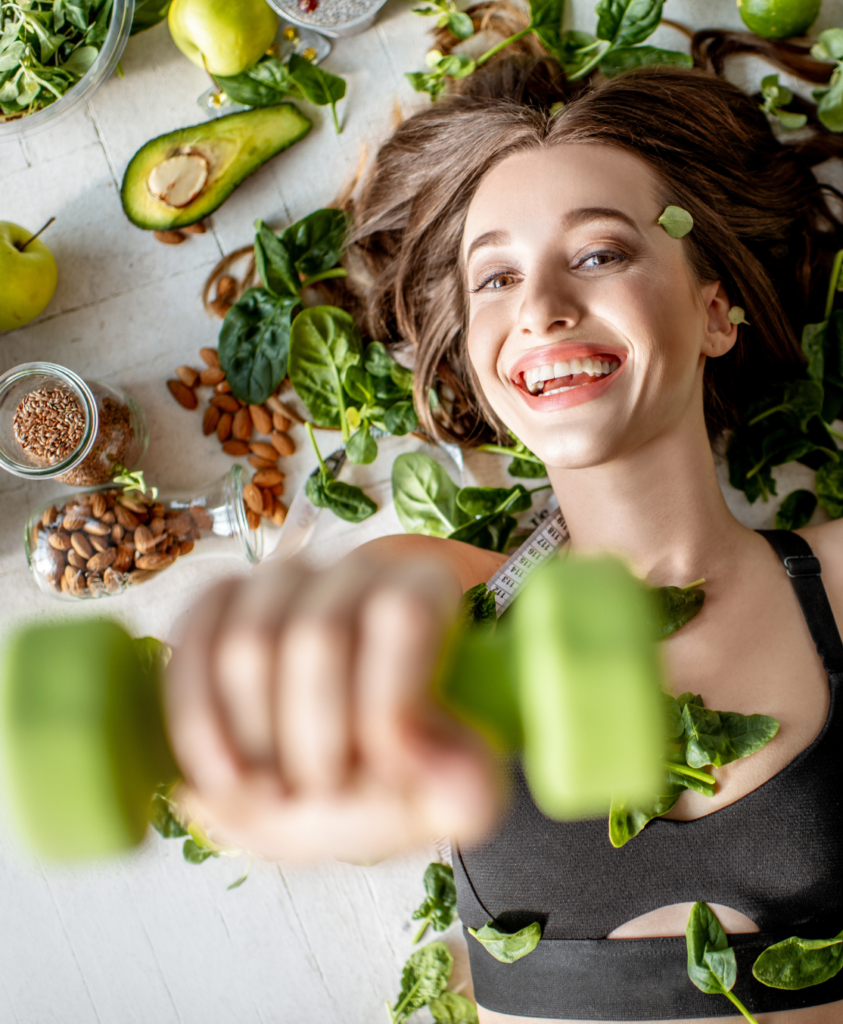 Women holding green weight surrounded by healthy food