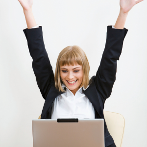 Excited woman with hands up looking at laptop