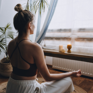 Female meditating by window