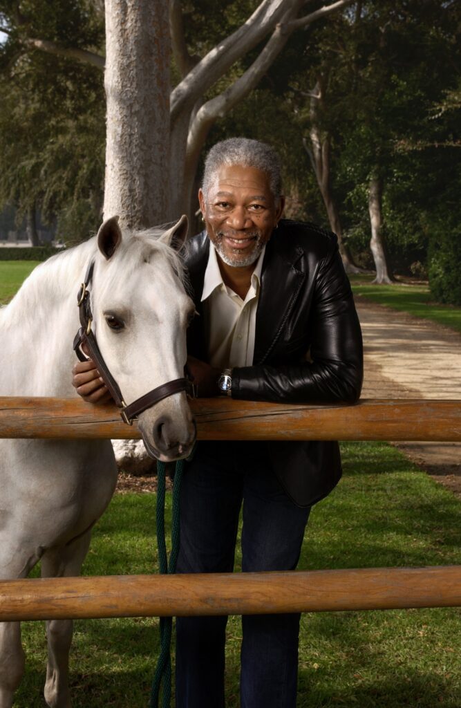 Morgan Freeman standing with white horse