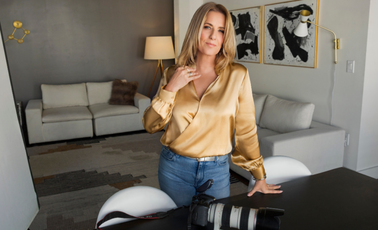 Starla in yellow shirt with camera on desk