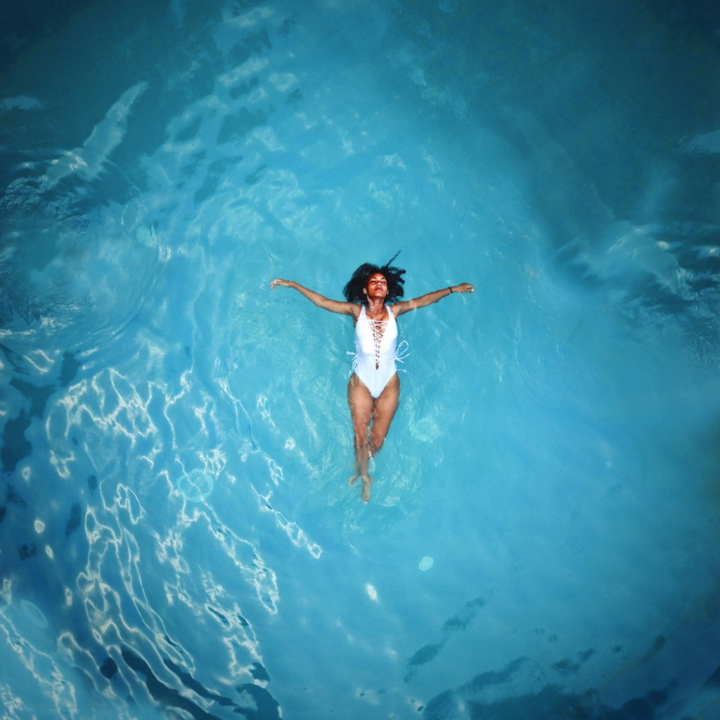 black woman in white swim suit floating in water