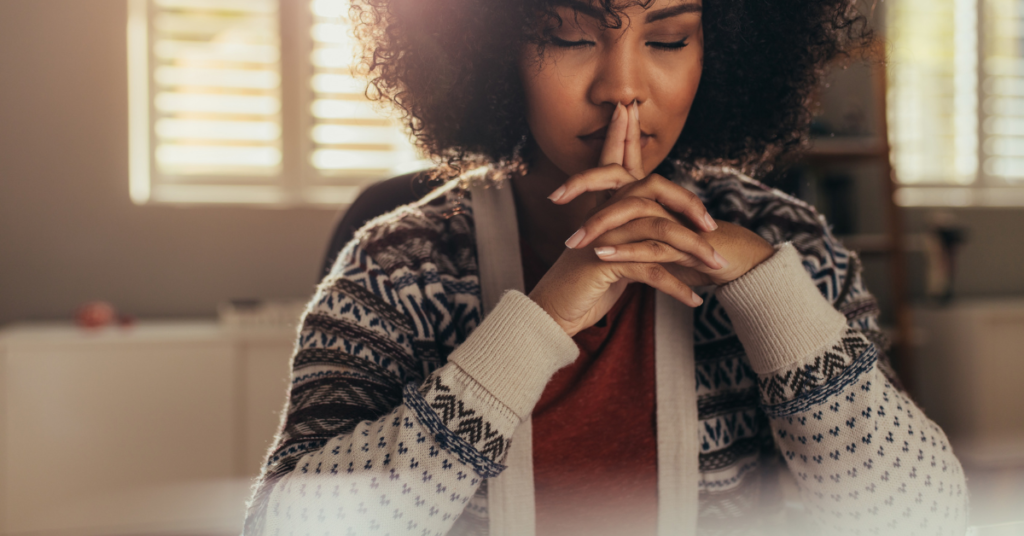 black woman with eyes closed and meditating