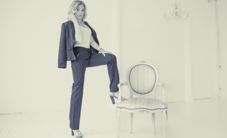 business woman with hand on leg and a leg on a chair