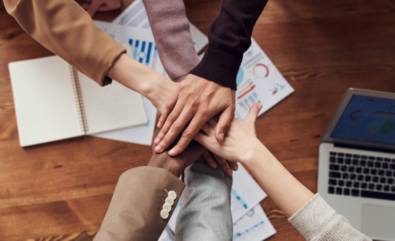 diverse hands of business people meeting over table of paper work