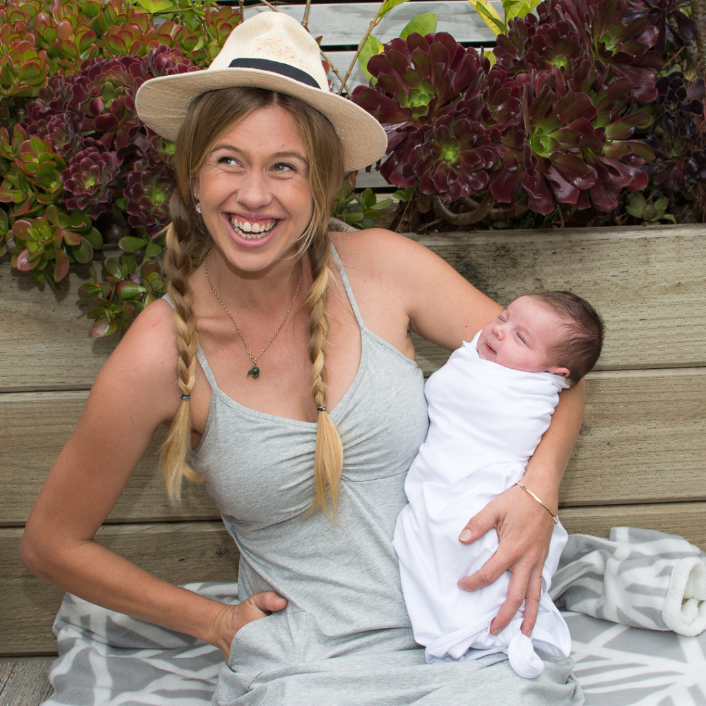 woman smiling holding baby while sitting on patio chait