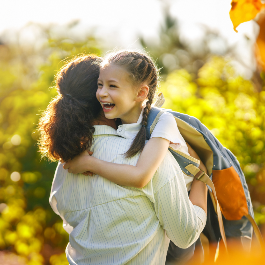 mom hugging daughter goodbye before school