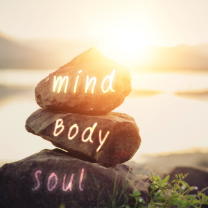 mind body soul words on rocks facing sunset