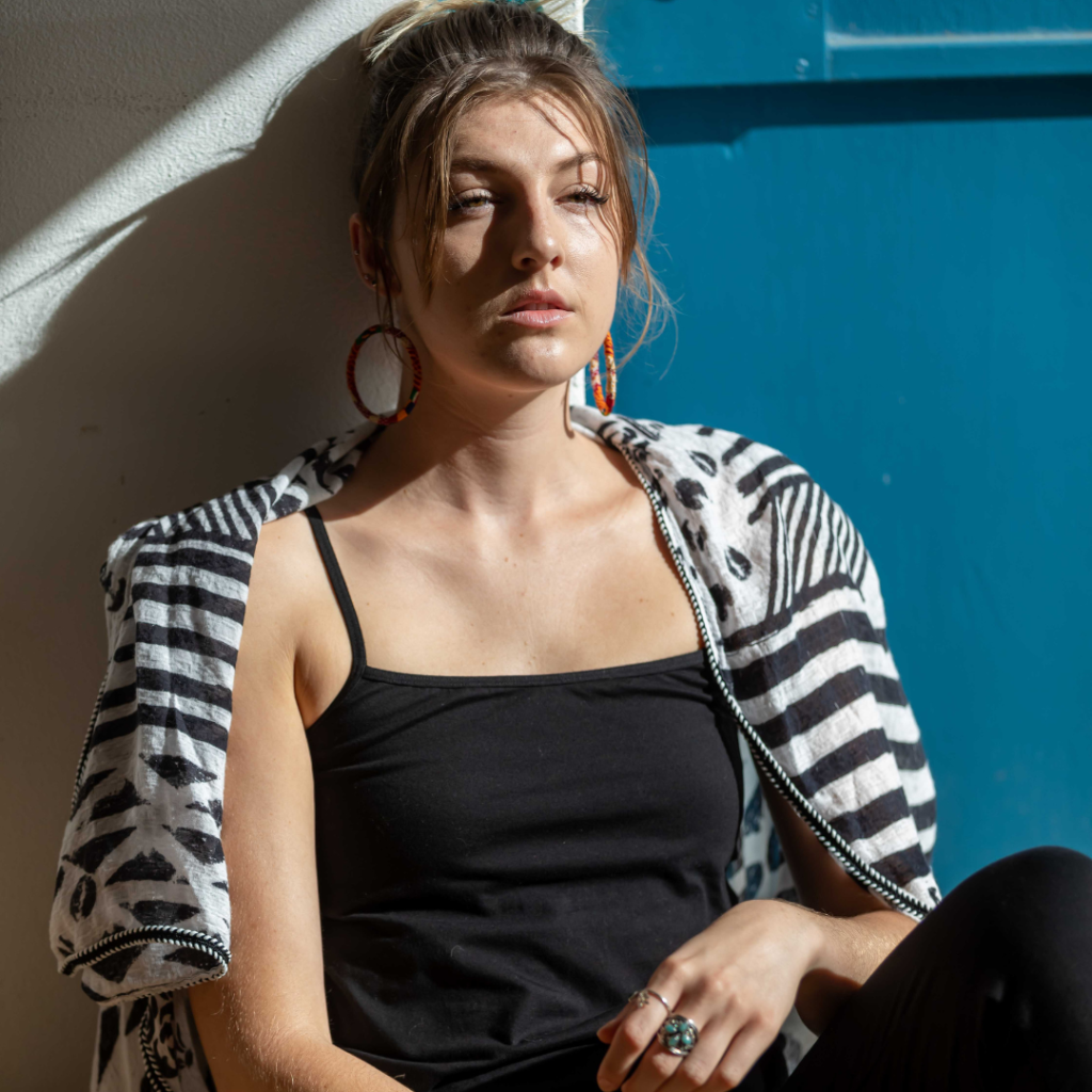 stylish girl sitting against wall