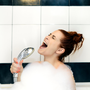 woman singing in a bathtub with lots of bubbles