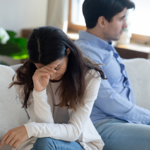 woman with face in her hand sitting next to man