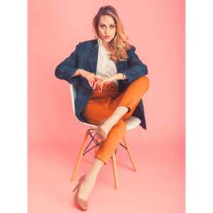 woman with white shirt and orange pants sitting in a chair