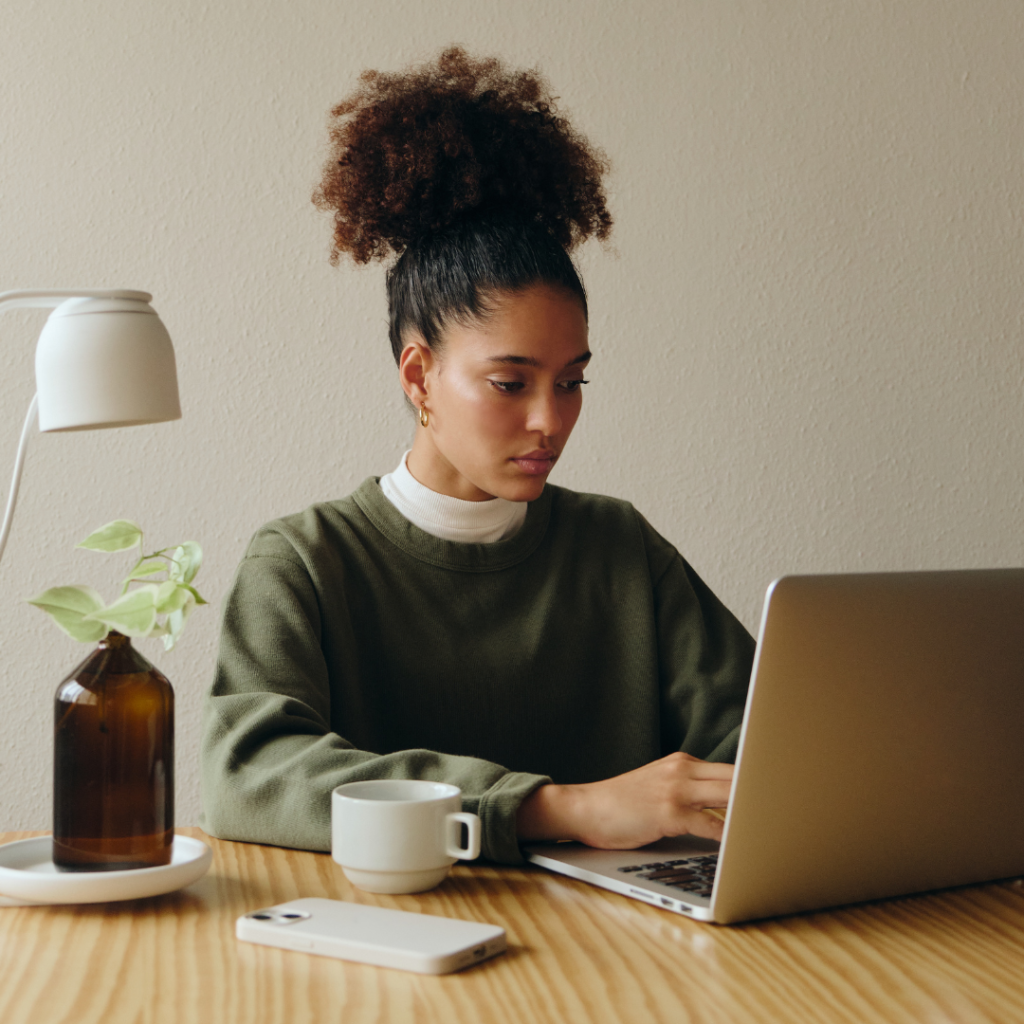 black woman sitting at desk working on laptop 