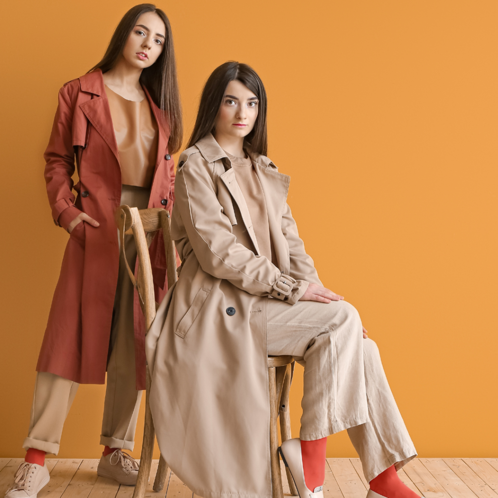 fashionable woman standing and sitting with orange background