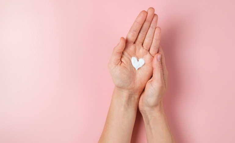 Female hands with lotion on it with a heart