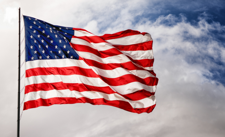 american flag waving in the wind with cloudy sky background