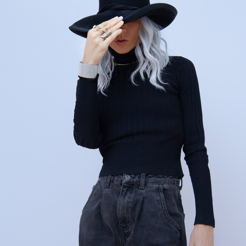 fall fashion model in black jeans, black shirt, and black hat