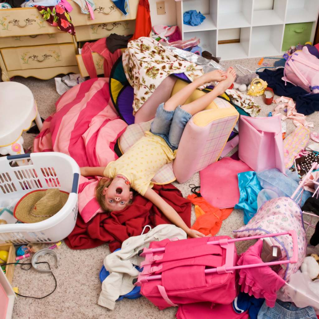 little girl laying on mess in messy room