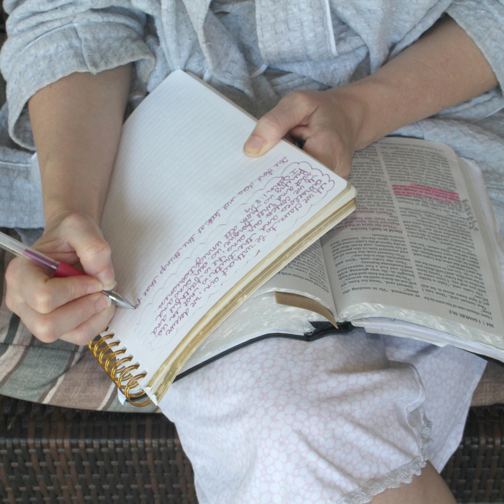 woman taking notes with bible