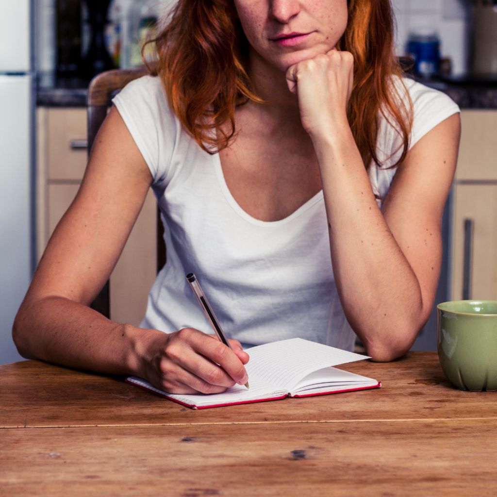 woman thinking and making list at desk