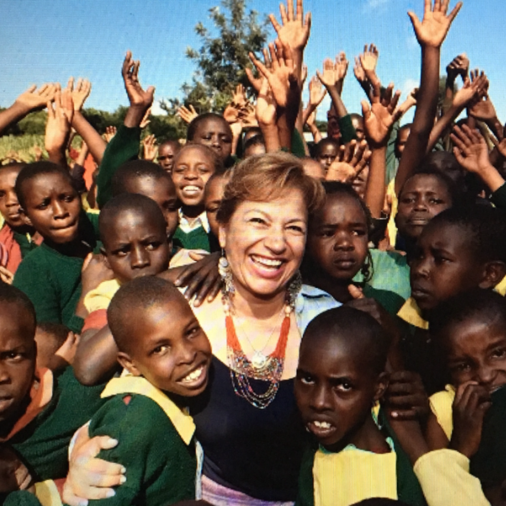 Betty Uribe surrounded by many children while volunteering