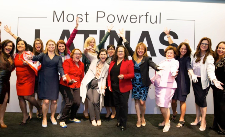 women standing in front of wall that says "most powerful latinas"