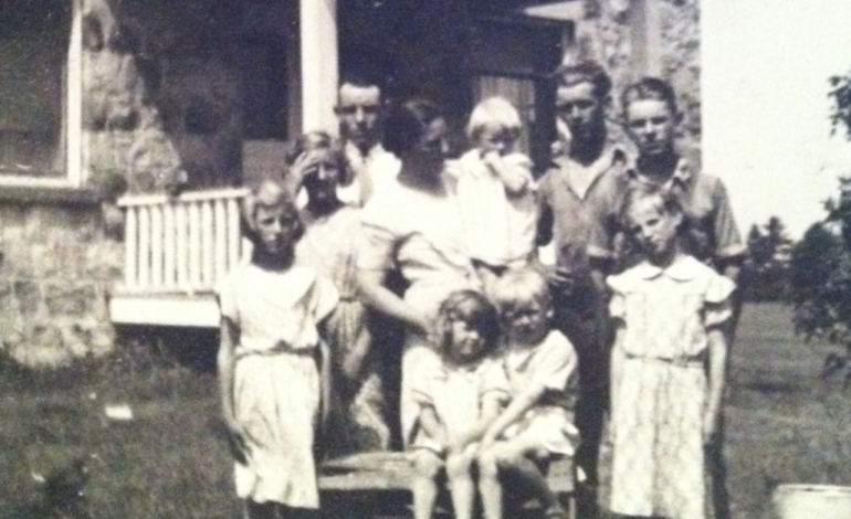 old photo of family in front of old stone house