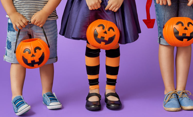 kids in halloween costumes holding candy buckets