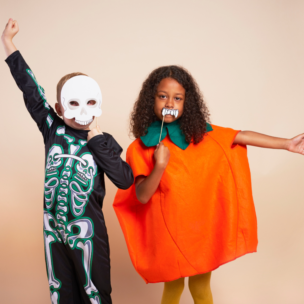 two kids posing in halloween costumes