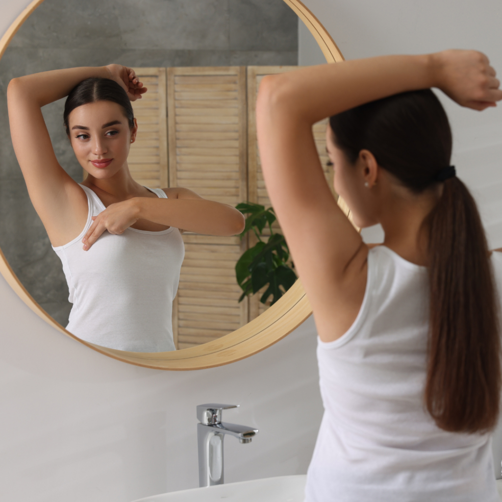 woman performing self breast exam in mirror