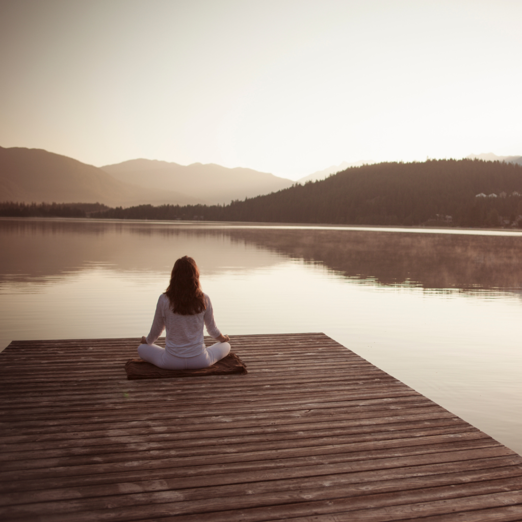 woman meditating on dock