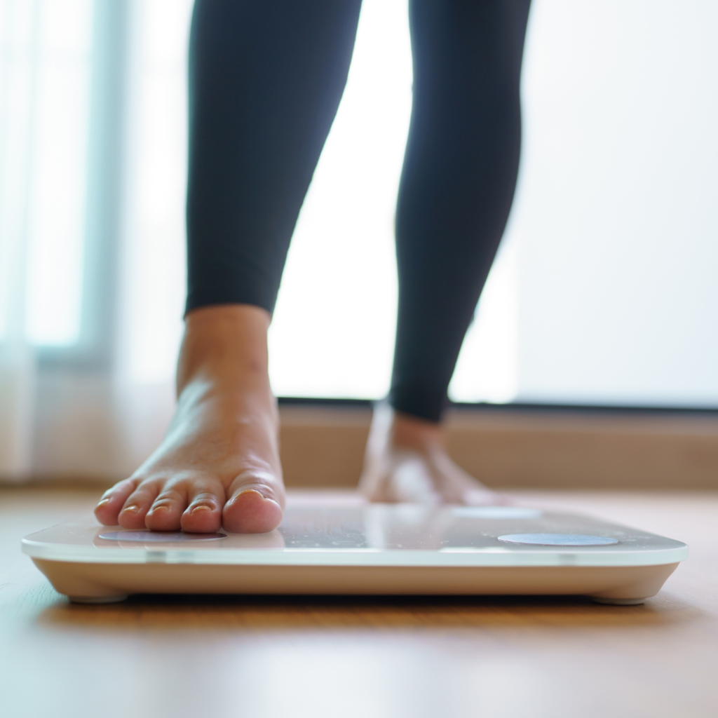 woman's feet stepping on scale