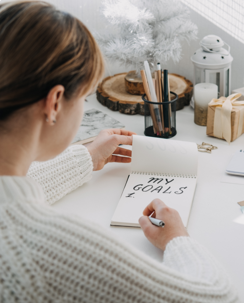 Woman writing in a goals journal