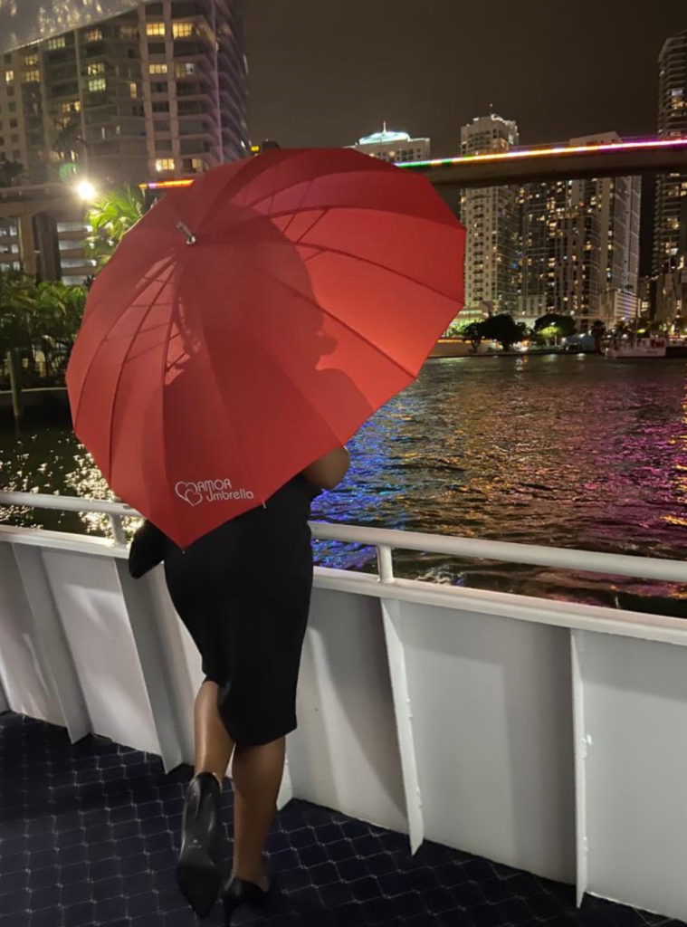 Woman holding Amor Umbrella looking out to Miami waterway