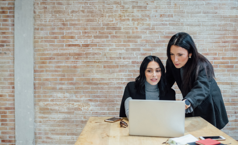 2 females working together on computer at desk