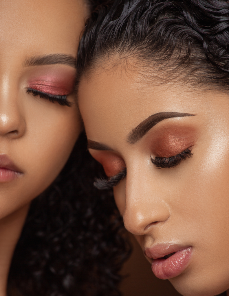 2 women heads together with brown makeup