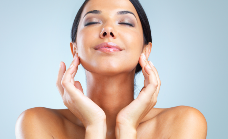 Woman putting 2 hands to cheeks rubbing face cream