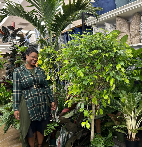 Black woman in green by tropical plants