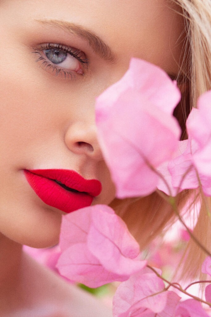 Women with pink flower over face and eye
