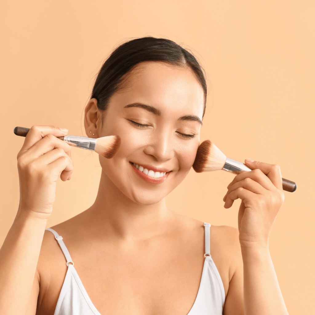 Woman with 2 blush brushes on cheeks