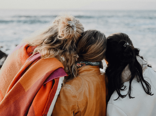 Women at beach heads together